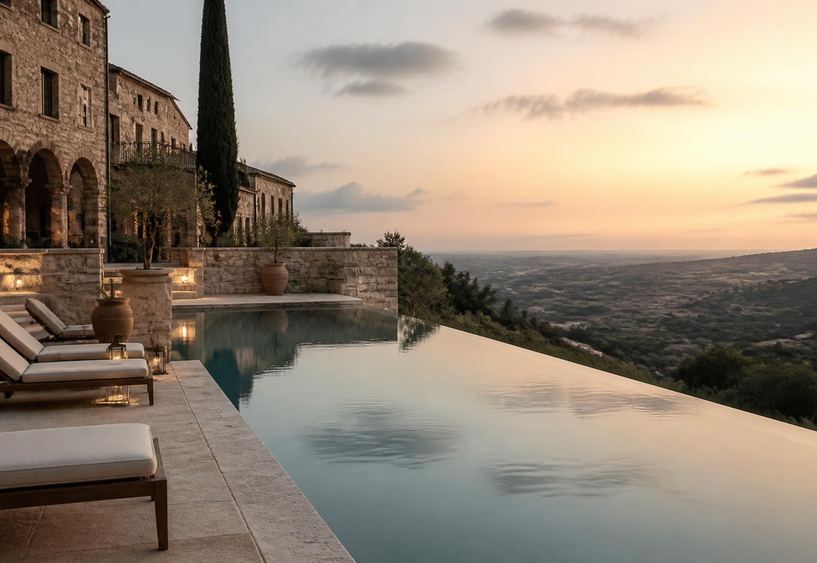 Stone hillside resort terrace overlooking a valley at dusk